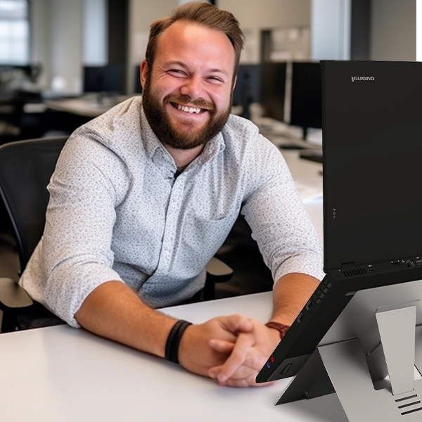user smiling in front of a laptop on the Standivarius Oryx evo D