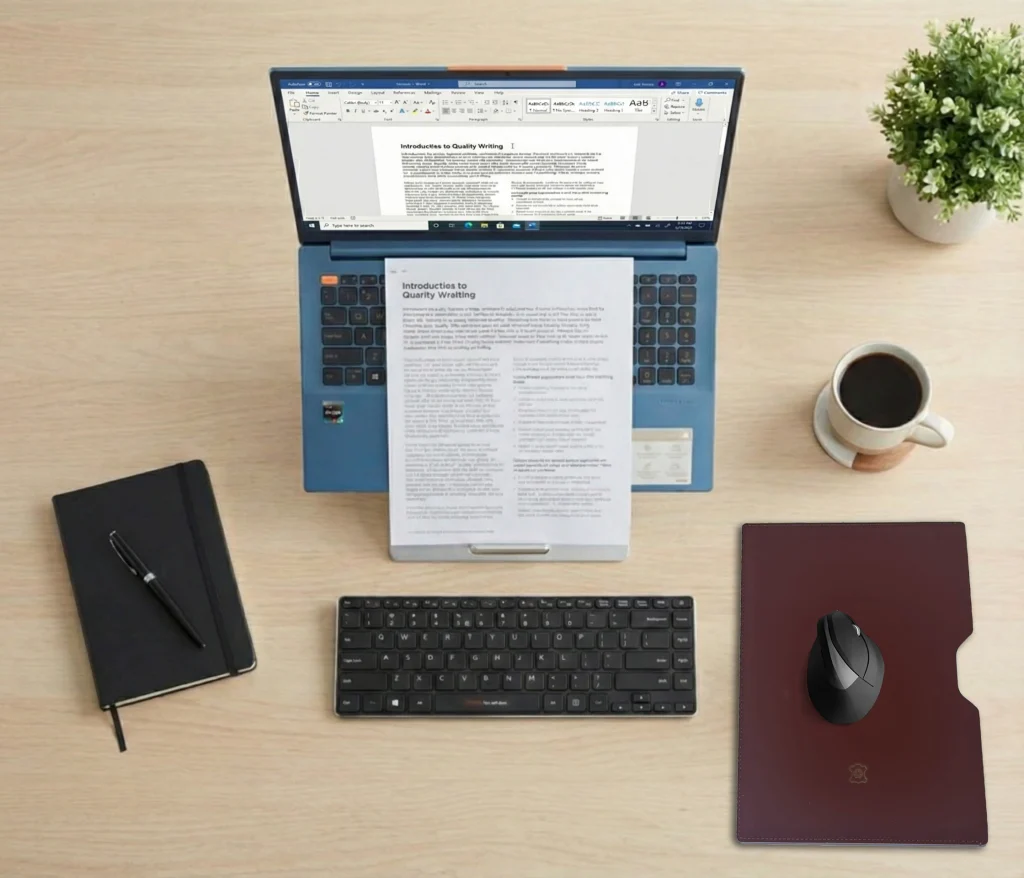 Top-down view of a desk showing the Oryx Evo D holding a laptop and document in perfect alignment.